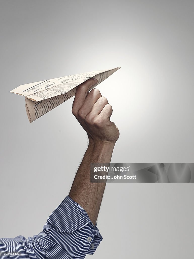 Hand holding a paper plane