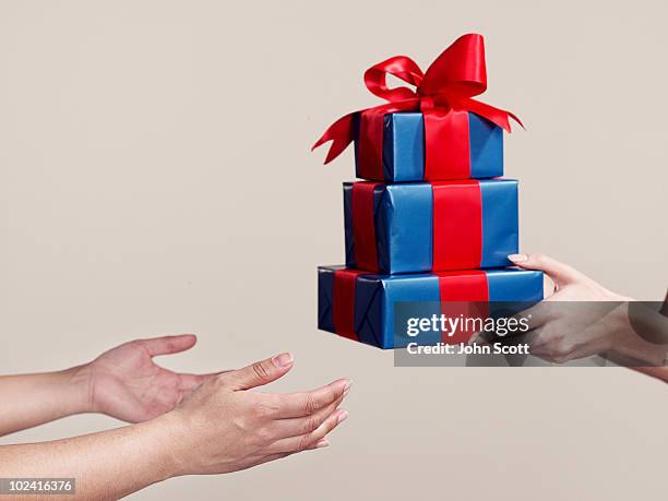 two people exchanging gifts, close-up of hands - överlämna bildbanksfoton och bilder