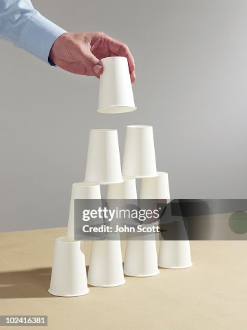 Man Building A Paper Cup House High-Res Stock Photo - Getty Images