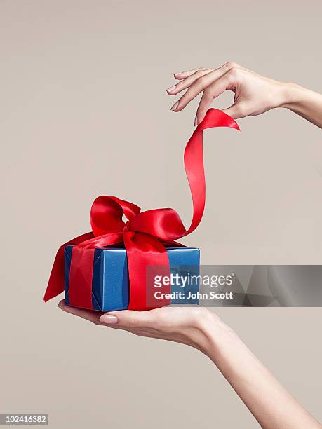 woman opening gift, close-up of hands - regalo foto e immagini stock