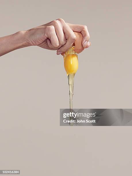 woman cracking an egg, close-up of hand - dotter stock-fotos und bilder