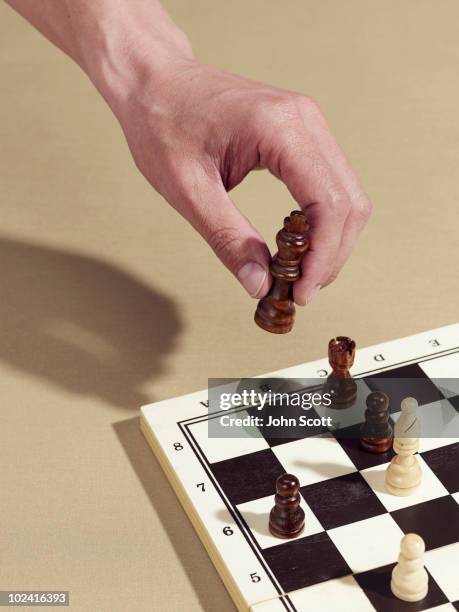 man holding a chess piece (king) - schach stock-fotos und bilder