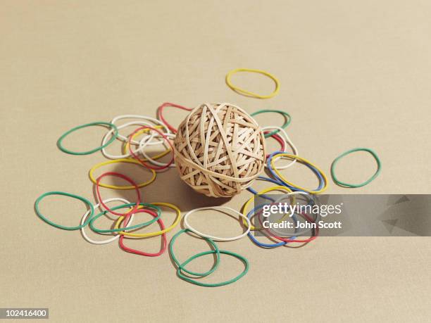 rubber band ball surrounded by rubber bands - elastic band ball stock pictures, royalty-free photos & images