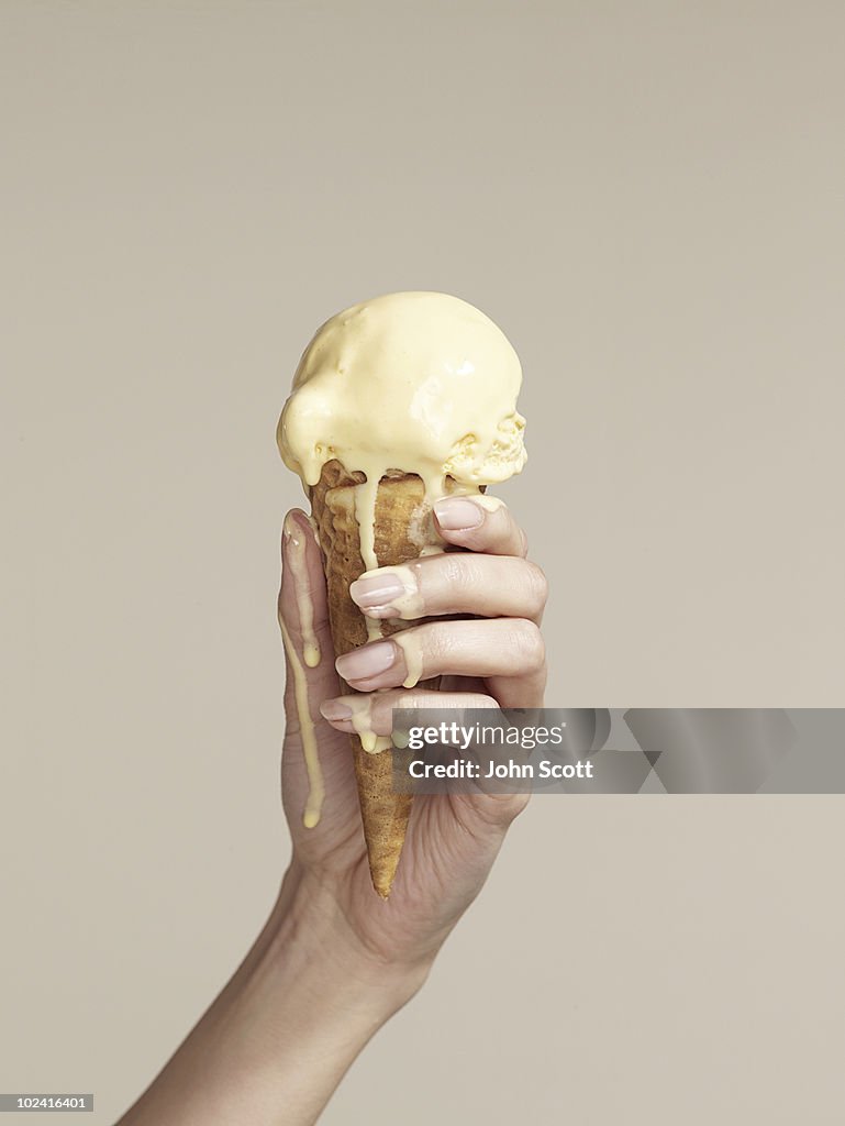 Woman holding melting ice cream cone