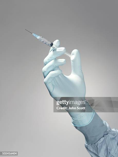 hand holding a syringe - seringa imagens e fotografias de stock