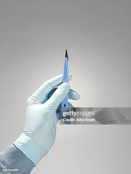 hand holding a scalpel  - scalpel stockfoto's en -beelden