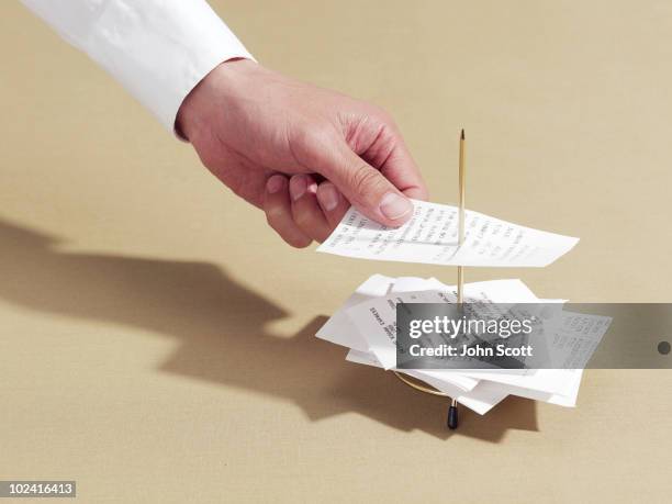 man putting a receipt onto a spike - receipt stock pictures, royalty-free photos & images