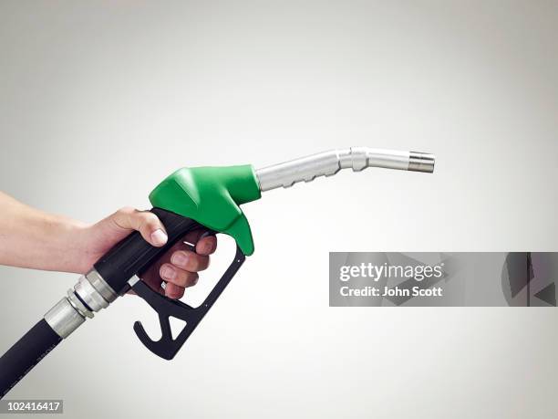 man holding a petrol pump, close-up of hand - brandstofpomp stockfoto's en -beelden