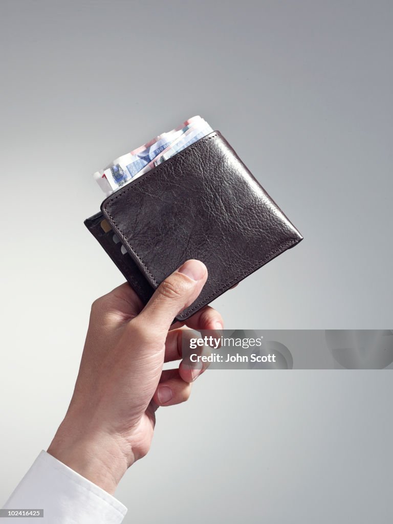 Man holding wallet, close-up of hand