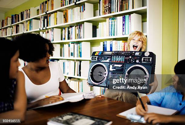 boy blaring boombox in library - girls boom box stock pictures, royalty-free photos & images