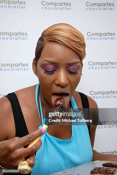 Reality TV star NeNe Leakes samples a fresh chocolate-covered marshmallow she has just created at Comparte's Chocolatier confectionary house on June...