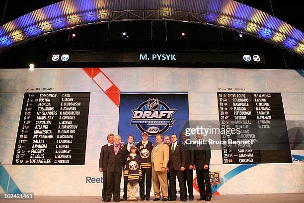 Mark Pysyk, drafted 23rd overall by the Buffalo Sabres, poses on stage with team personnel during the 2010 NHL Entry Draft at Staples Center on June...