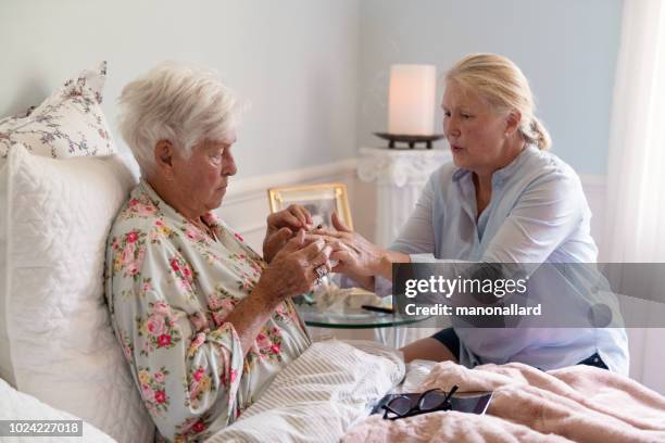 a woman teaches her mother how to smoke marijuana joint medicinal cannabis - end of life stock pictures, royalty-free photos & images