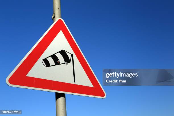 road sign "crosswind" with blue sky - road warning sign stock pictures, royalty-free photos & images