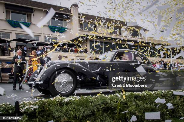 Confetti falls on a 1937 Alfa Romeo 8C 2900B Touring Berlinetta, owned by David and Ginny Sydorick, after winning the Best of Show award during the...