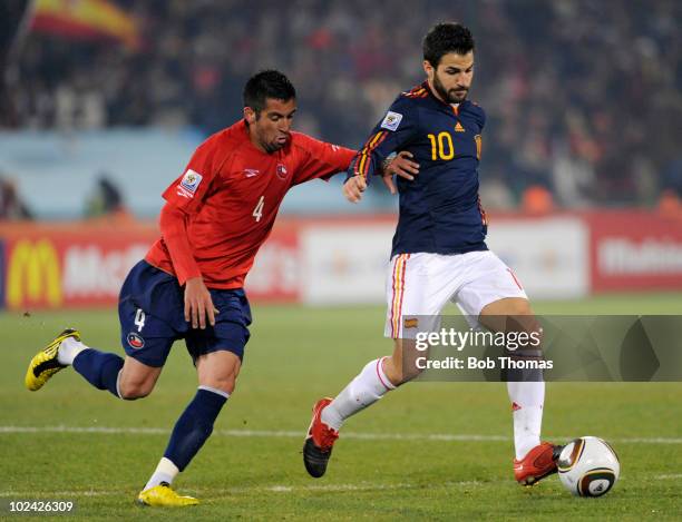 Cesc Fabregas of Spain is chased by Mauricio Isla of Chile during the 2010 FIFA World Cup South Africa Group H match between Chile and Spain at...