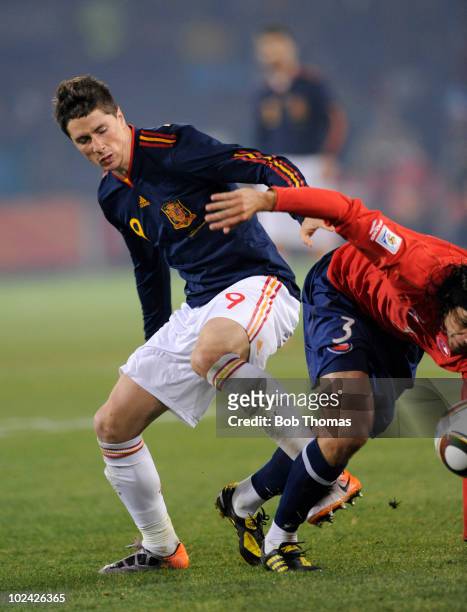 Fernando Torres of Spain clashes with Waldo Ponce of Chile during the 2010 FIFA World Cup South Africa Group H match between Chile and Spain at...