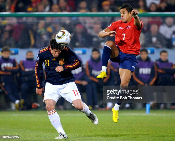 Joan Capdevila of Spain heads the ball clear of Alexis Sanzhez of Chile during the 2010 FIFA World Cup South Africa Group H match between Chile and...