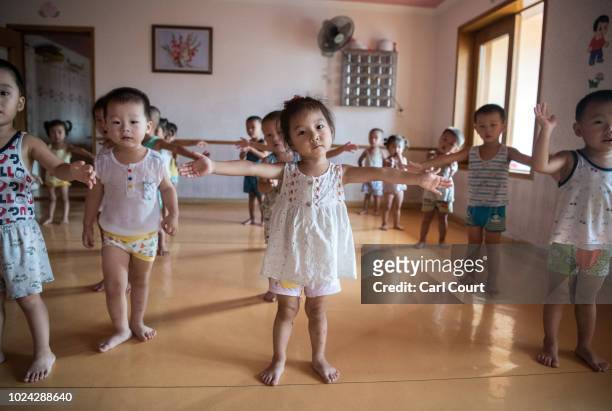 Employee's children take part in a music and dance lesson at a kindergarten in the Kim Jong Suk Silk Factory on August 21, 2018 in Pyongyang, North...