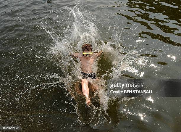 Swimmer dives jumps into the Serpentine Lido in the center of London on June 26, 2010 as Britain enjoys summer weather. AFP PHOTO/ BEN STANSALL