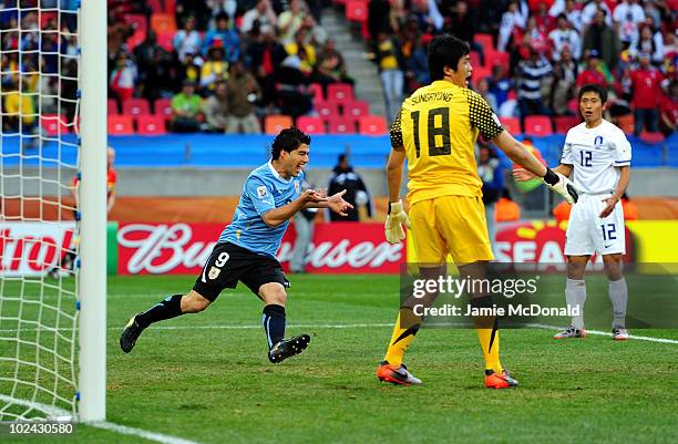 Luis Suarez of Uruguay celebrates scoring the opening goal past Jung Sung-Ryong of South Korea during the 2010 FIFA World Cup South Africa Round of...