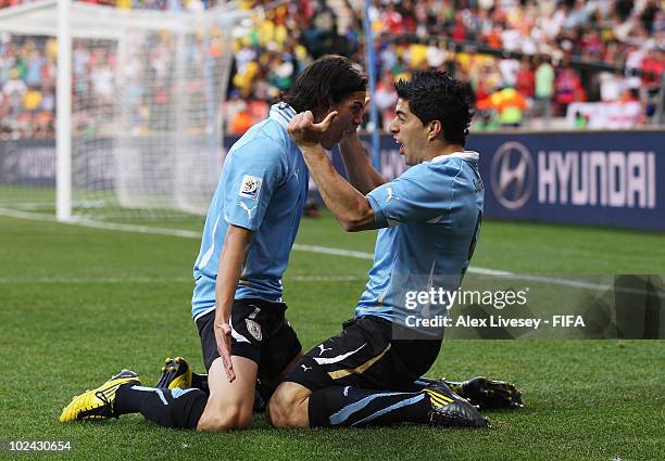 Luis Suarez of Uruguay celebrates scoring with teammate Edinson Cavani during the 2010 FIFA World Cup South Africa Round of Sixteen match between...