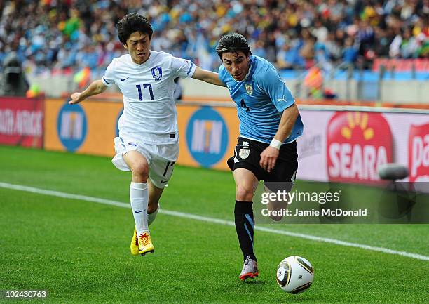 Jorge Fucile of Uruguay is closed down by Lee Chung-Yong of South Korea during the 2010 FIFA World Cup South Africa Round of Sixteen match between...