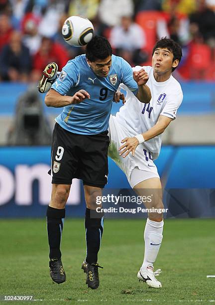 Lee Jung-Soo of South Korea challenges Luis Suarez of Uruguay during the 2010 FIFA World Cup South Africa Round of Sixteen match between Uruguay and...