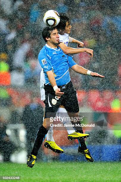 Mauricio Victorino of Uruguay and Park Chu-Young of South Korea jump for the ball during the 2010 FIFA World Cup South Africa Round of Sixteen match...