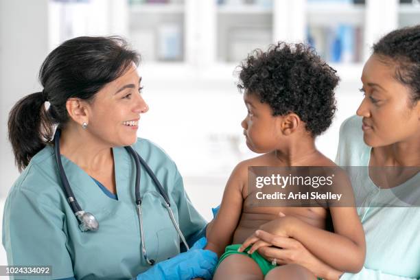 doctor examining a child - ariel shot stockfoto's en -beelden