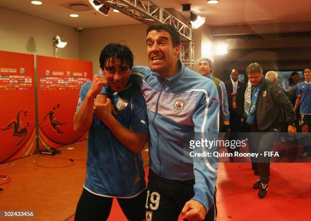 Jorge Fucile of Uruguay celebrates with teammate Andres Scotti after the 2010 FIFA World Cup South Africa Round of Sixteen match between Uruguay and...
