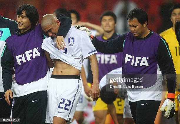 Cha Du-Ri of South Korea is consoled by team mate Ahn Jung-Hwan and coaching staff after being knocked out of the competition during the 2010 FIFA...