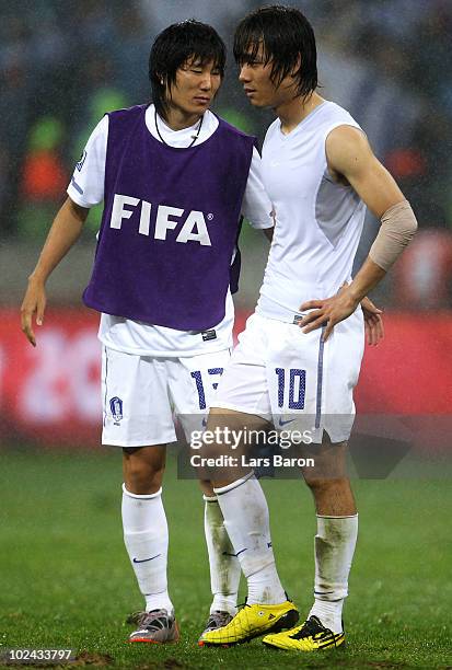 Kim Jae-Sung and Park Chu-Young of South Korea leave the field dejected after being knocked out of the competition during the 2010 FIFA World Cup...