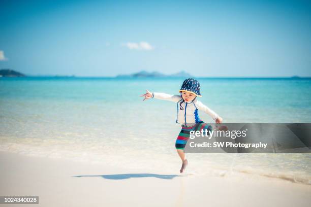 very cute chinese boy playing on the beach - whitsunday island stock pictures, royalty-free photos & images