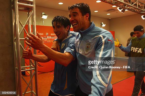 Jorge Fucile of Uruguay celebrates with teammate Andres Scotti after the 2010 FIFA World Cup South Africa Round of Sixteen match between Uruguay and...