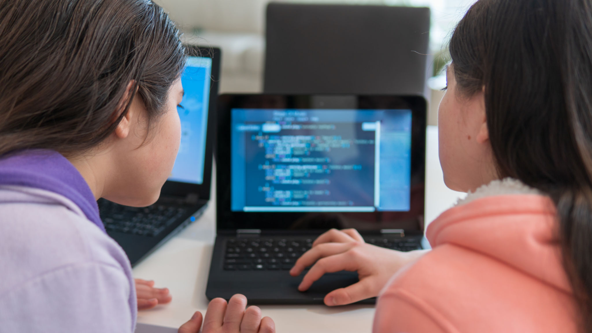 Girls learning to code on laptop computers at home Girls learning to code on laptop computers at home