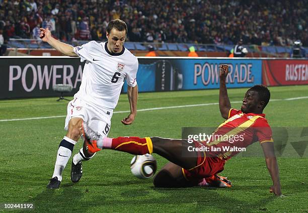 Steve Cherundolo of the United States is challenged by Sulley Muntari of Ghana during the 2010 FIFA World Cup South Africa Round of Sixteen match...