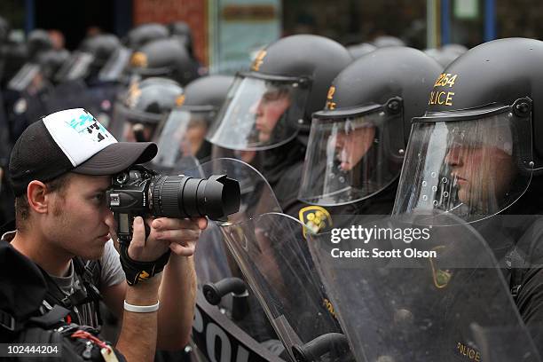 Photographer takes pictures as police officers form a line to hold back demonstrators protesting the G8/G20 summits on June 26, 2010 in Toronto,...
