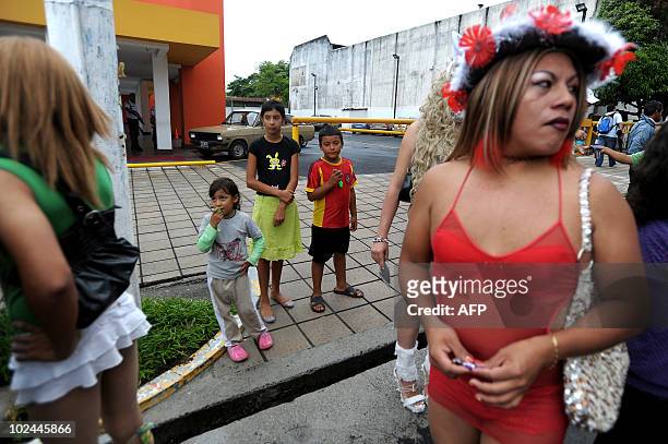Children watch as drag queens take part in the annual Gay Pride Parade in San Salvador, El Salvador, on June 26, 2010. Hundreds of people took to the...