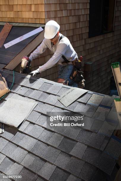 man installing asphalt roof - rooftop stock pictures, royalty-free photos & images