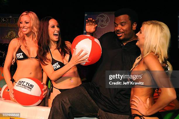 Actor Craig Robinson poses with models as he arrives at the "Hot Tub Time Machine" Blu-ray and DVD launch party at the Kandyland V red carpet at the...