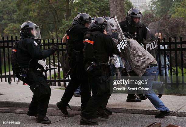 Police officers tackle and detain a National Post photographer while he was photographing protestors demonstrating against the G8/G20 summits June...