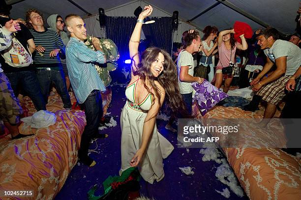 Revellers have a pillow fight on two giant beds within the "Slumber Rave" in the early hours of the final day of the Glastonbury festival near...