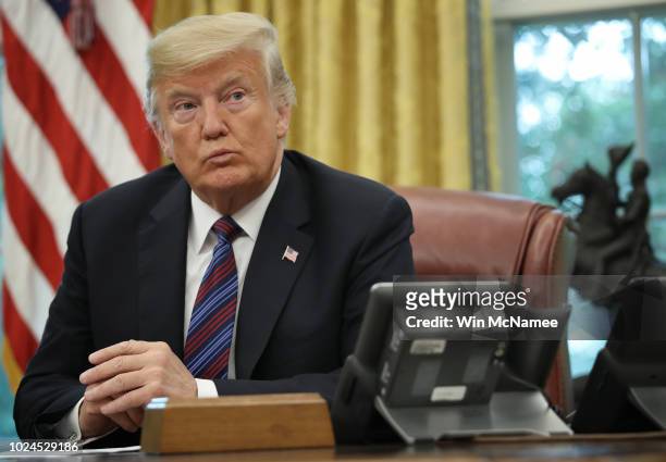 President Donald Trump speaks on the telephone via speakerphone with Mexican President Enrique Pena Nieto in the Oval Office of the White House on...