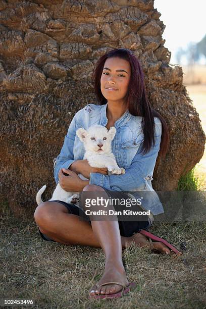 Chantelle Tagoe, the fiancee of England international football player Emile Heskey, sits with Acinonyx the six week old white Lion cub at the Cheetah...