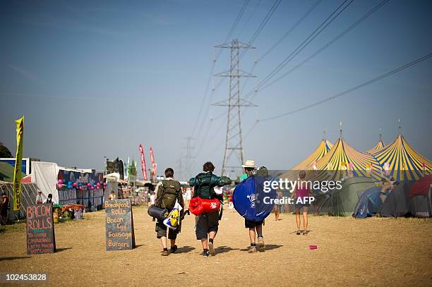 Revellers leave the site early to beat the rush on the final day of the Glastonbury festival near Pilton, Somerset on June 27, 2010. Celebrating its...