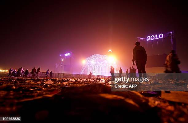 Revellers head back to their tents in the early hours of the final day of the Glastonbury festival near Pilton, Somerset on June 27, 2010....