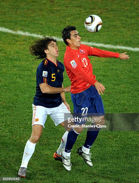 Esteban Paredes of Chile wins the ball ahead of Carles Puyol of Spain during the 2010 FIFA World Cup South Africa Group H match between Chile and...