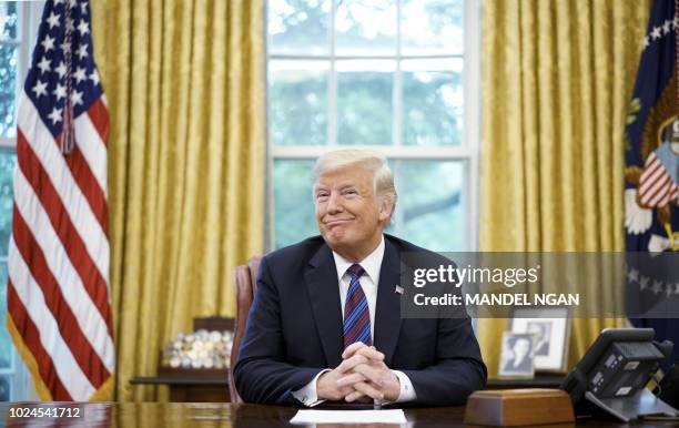 President Donald Trump smiles during a phone conversation with Mexico's President Enrique Pena Nieto on trade in the Oval Office of the White House...