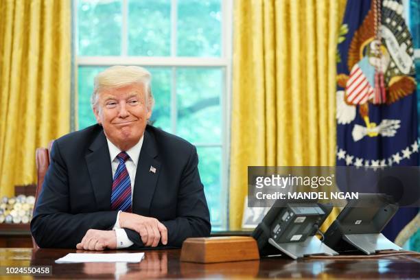 President Donald Trump listens during a phone conversation with Mexico's President Enrique Pena Nieto on trade in the Oval Office of the White House...